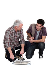 Tiler showing new starter the correct technique