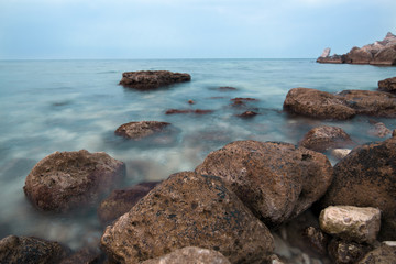 The coast of the blue sea with boulders