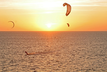 kitesurfers at sunset