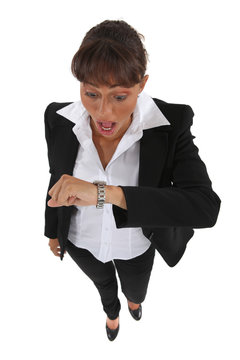 Businesswoman looking at her watch in alarm