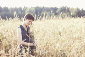 Naklejka na ściany i meble Girl in blue dress hug armful of wheat