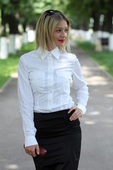 Portrait of young businesswoman standing in sunny park