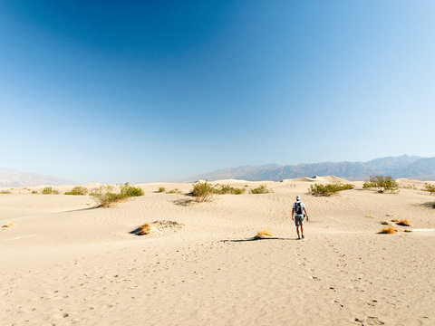 Man walking alone in the desert sand dunes