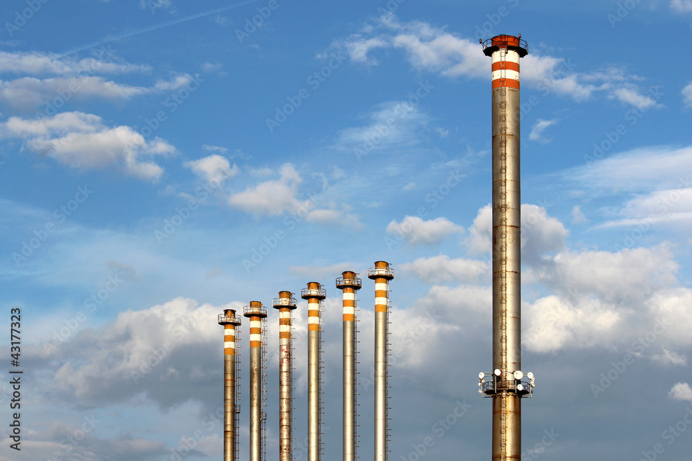 Wall mural group of tall chimney from steel factory under sky