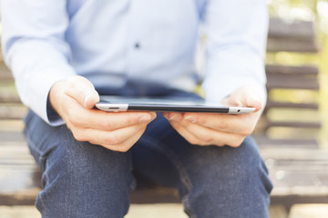 Businessman With Tablet Computer on bench in park