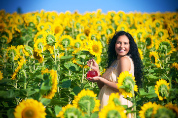 Naklejka premium Smiling pregnant woman in sunflowers
