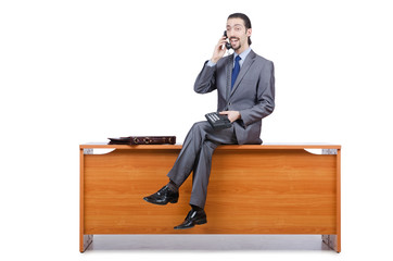 Businessman sitting on desk and speaking phone