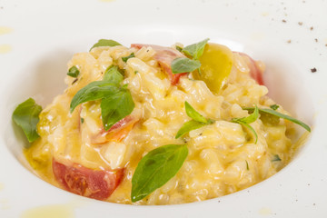 photo of delicious risotto dish with herbs and tomato on white b