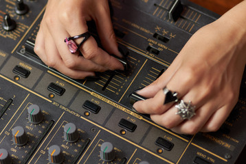 Hands of female DJ mixing music