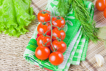 red ripe tomatoes with fresh greenery on a napkin