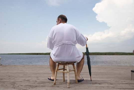 tourist in bathrobe with umbrella front of the Danube Delta
