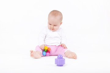 8 month old baby girl playing on the ground with her toys