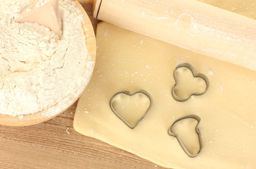 tins of cookies on the rolled out dough close-up