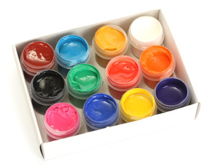 jars with colorful gouache in paper box isolated