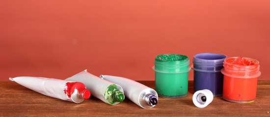 Tubes with colorful watercolors and jars with gouache