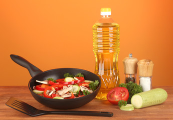 frying pan with vegetables on red background