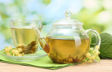 Panele Szklane Podświetlane  czajniczek i filiżanka z herbatą lipową i kwiatami