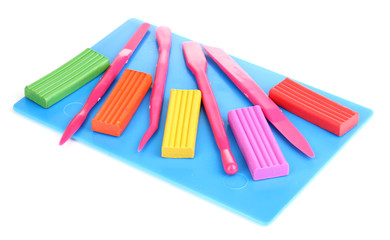 Children bright plasticine on desk with stacks isolated on