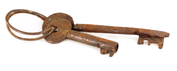 Rusty iron keys over white background