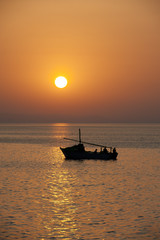 Fototapeta na wymiar Sunset over the ocean with a boat