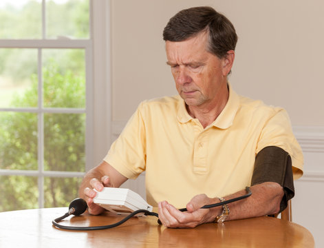 Senior Man Taking Blood Pressure At Home