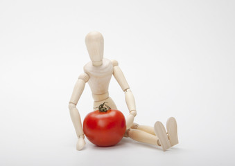 Wooden mannequin and red tomato