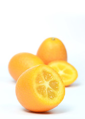 Group of sliced and whole kumquats on white background
