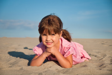 Cute little girl playing in the sand