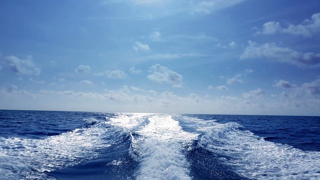 blue ocean sea with fast yacht boat wake foam of prop wash