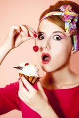 Fotobehang Style redhead girl with cake at pink background. © Masson
