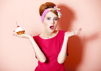Style redhead girl with cake at pink background.