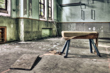 Dilapidated pommel horse in an abandoned school gymnasium