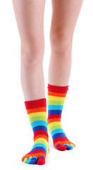 female legs in colorful striped socks isolated on white