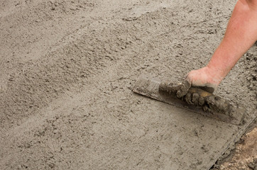 Worker with trowel finishing concrete