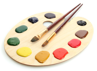 wooden art palette with  paint and brushes.isolated on white