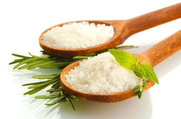 salt in spoons with fresh basil, thyme and rosemary isolated