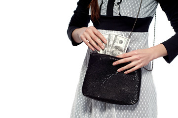 A young girl pulls dollars out of the bag. On a white background