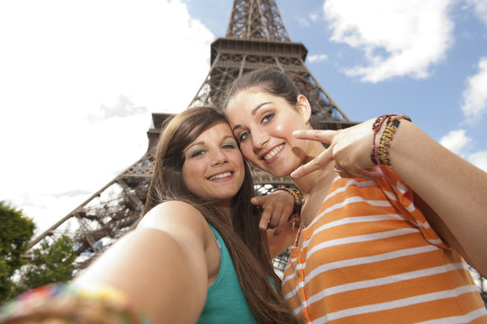 2 jeunes filles se prenant en photo devant la Tour Eiffel
