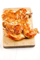 grilled Chicken Tabaka on wooden board, white backdrop