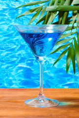 Glass of cocktail on blue sea background