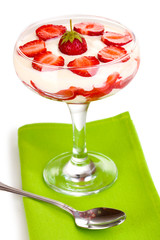 Glass of ripe strawberries with cream isolated on white