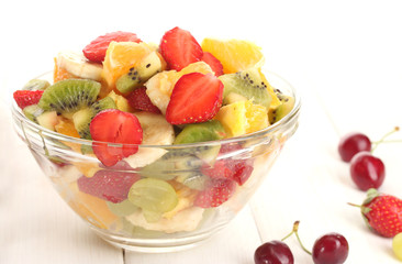 glass bowl with  fresh fruits salad and berries
