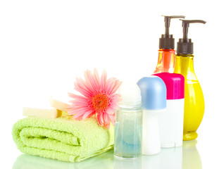 cosmetics bottles with towels and flower isolated on white