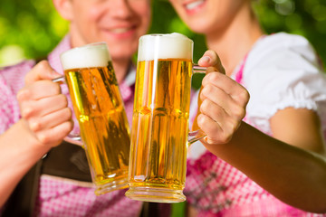 Glückliches Paar mit Bier im Biergarten Restaurant
