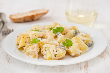 potato salad with sauce on the white plate