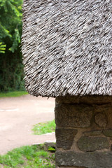 Chaumière - détails toit et mur de pierre