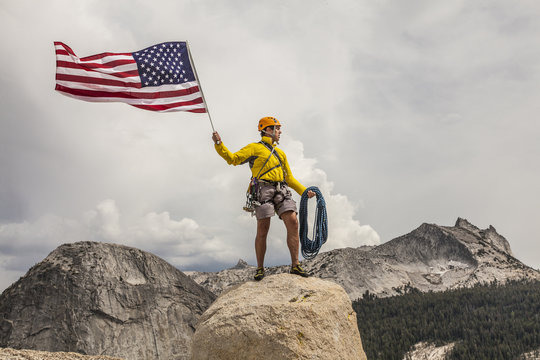 Climber raising the flag on the summit.