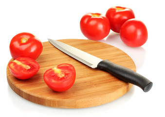 Ripe red tomatoes and knife on cutting board isolated on white