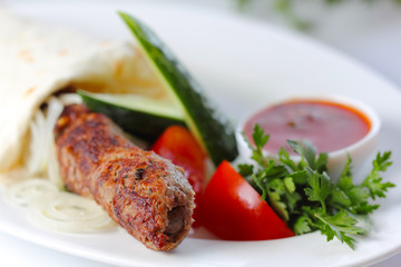 shish pork kebab with greens and vegetables