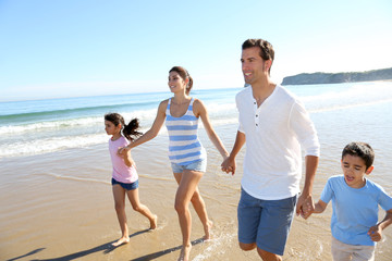 Family having fun running on the beach